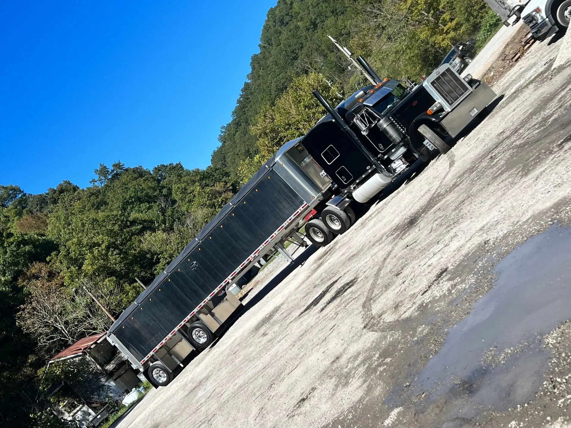 Black Mullins Trucking Peterbilt pulling an end dump trailer