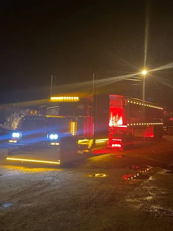 Mullins Trucking tractor-trailer with marker lights on at night